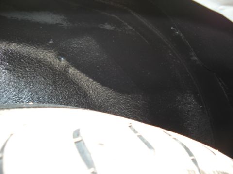 1998 Ford Taurus - Close-up of a vehicle's wheel well liner, showing the textured black surface and part of the tire.