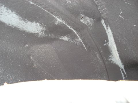 1998 Ford Taurus - Close-up of a vehicle's wheel well liner shows wear and tear.