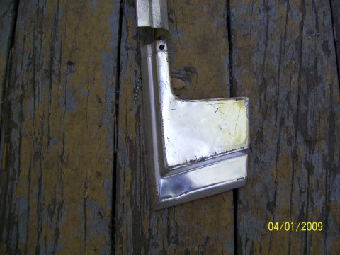 1972 Ford Ranchero - A chrome trim piece, possibly for a vehicle, rests on a weathered wooden surface. The date 04/01/2009 is visible in the lower right corner.