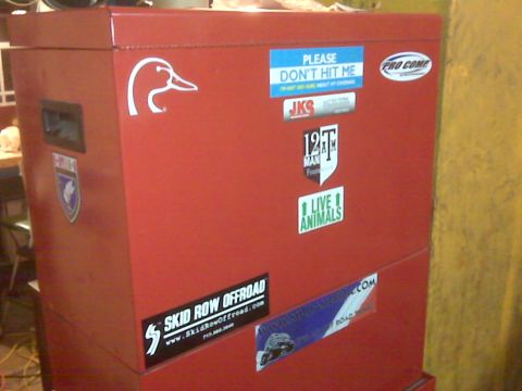 2008 Jeep Wrangler - A red toolbox is adorned with various stickers, including a duck logo and several humorous or brand-related decals.