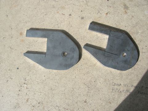 1996 Ford Bronco - Two metal suspension components are shown laid out on a concrete surface, with some handwritten markings visible on the right part.