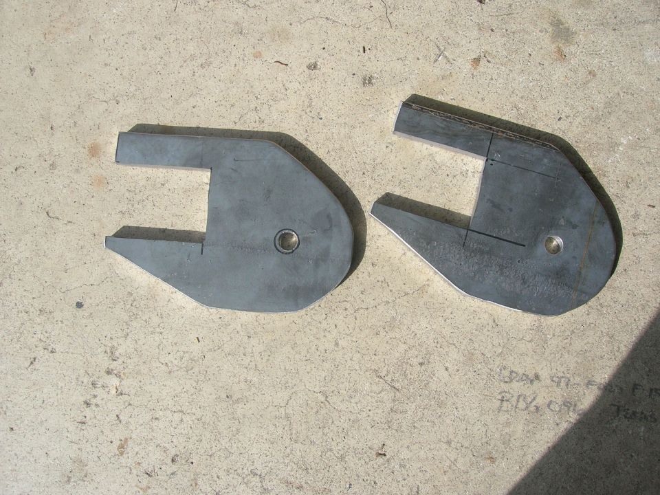 Two C-shaped metal suspension parts on concrete floor