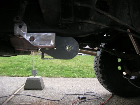 1996 Ford Bronco - Close-up of the rear suspension system on a 1996 Ford Bronco, showing a custom metal bracket attached to the frame.