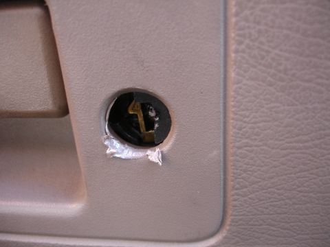 1995 Ford Taurus - Interior door lock cylinder showing damage around the keyhole.