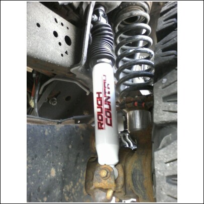 2005 Ford F-250 - Close-up view of a vehicle's suspension system, showing a shock absorber and coil spring assembly.