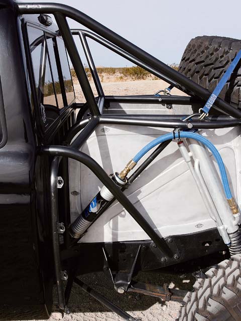 1984 Ford Bronco - Custom off-road modifications are visible on this truck's bed, including a roll cage and heavy-duty suspension components.