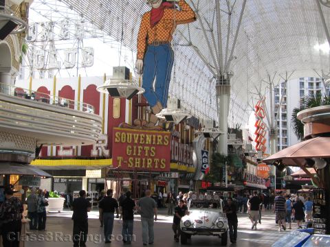 1990 Ford Bronco - white Volkswagen Beetle baja bug sits in a covered casino mall beneath the giant neon cowboy and a Souvenirs sign.