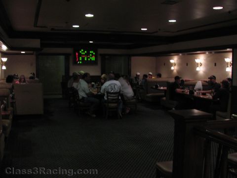 1990 Ford Bronco - Patrons sit at tables and booths in a dimly lit restaurant or lounge with a small lit display on the far wall.