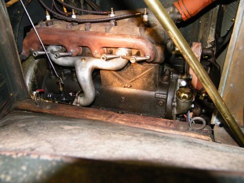 1909 Ford Model T - The engine compartment of an antique automobile shows its internal combustion engine and associated components.