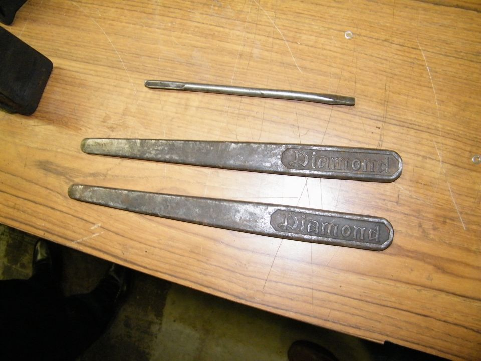 Two Diamond brand tools and a flathead screwdriver on wood