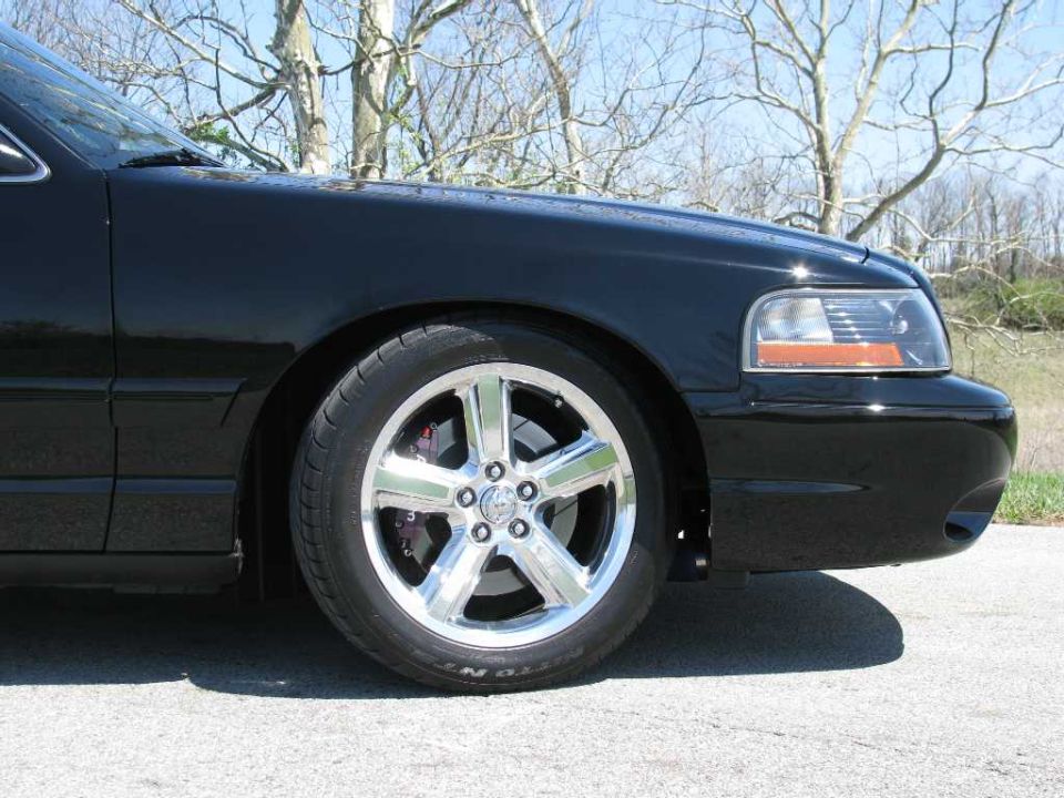 Front fender and chrome wheel of a black 2003 Mercury Marauder