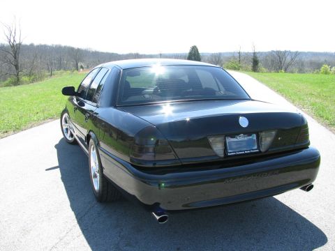 2003 Mercury Marauder - A black 2003 Mercury Marauder sedan is seen from the rear on a sunny day, with a scenic rural landscape behind it.