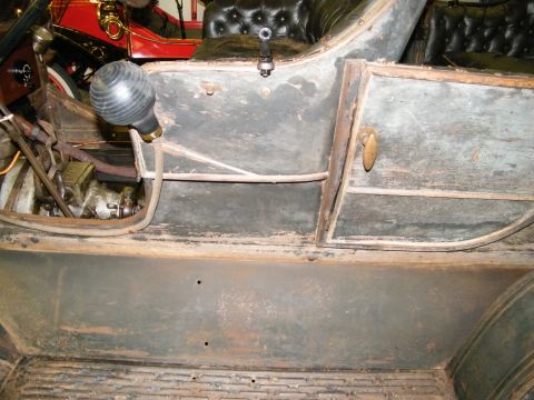 1909 Ford Model T - Close-up of the interior of a vintage automobile, showing worn surfaces and a prominent horn.