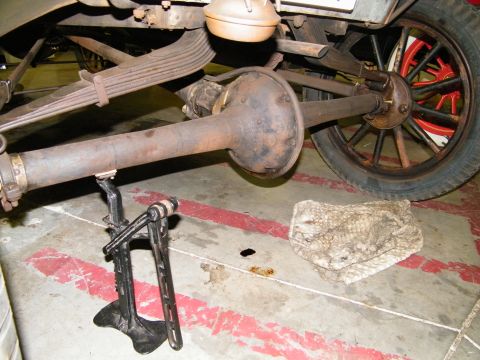 1909 Ford Model T - Close-up of the rear axle and suspension components of a 1909 Ford Model T, with a floor jack in place.