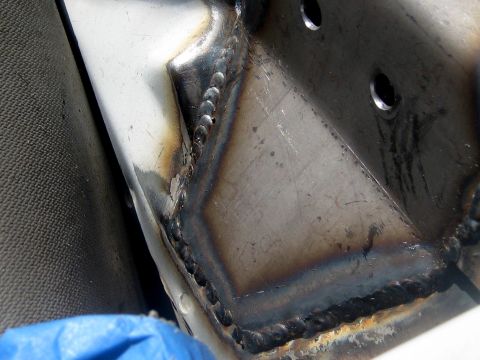 1996 Ford Bronco - This image shows a section of a metal frame with numerous welds and two pre-drilled holes.