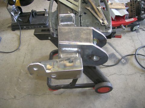 1996 Ford Bronco - A fabricated metal component, likely for a vehicle's suspension system, is shown close-up on a workbench.