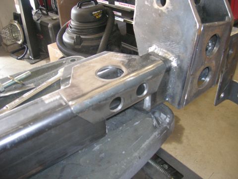 1996 Ford Bronco - A close-up view of a fabricated metal component, likely for a vehicle's suspension system, in a workshop.