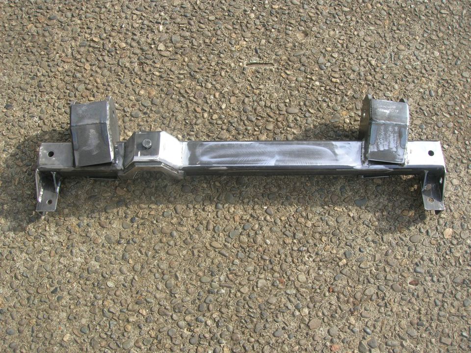 Metal suspension crossmember with welded brackets