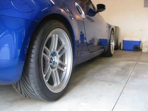 1990 Ford Probe - A blue sports car is parked in a garage, viewed from the side, highlighting its custom wheels.