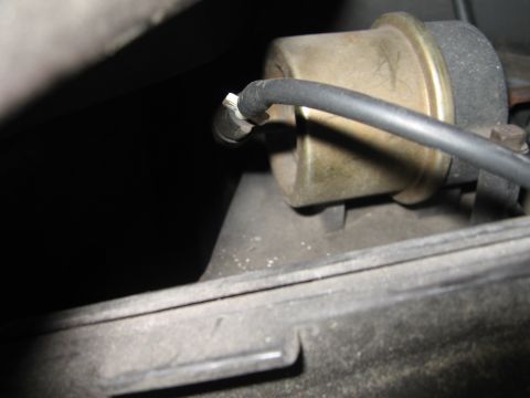 1994 Ford Bronco - Close-up of a vacuum hose connected to a diaphragm actuator, likely part of a vehicle's emission control system.