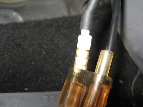 1994 Ford Bronco - A close-up view of a vacuum hose connector, showing the black tubing and white fitting.