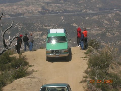 1985 Ford Bronco - A group of people observe the view from a cliff edge next to a green Ford truck.