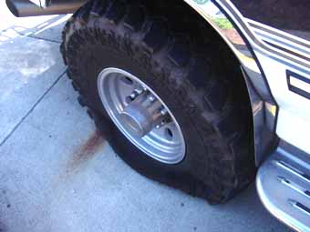 1994 Ford C-350 (Centurion Conversions) - A close-up view of a large truck tire and part of the fender.