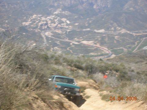 1985 Ford Bronco - Off-roading in a green SUV on a challenging dirt path.