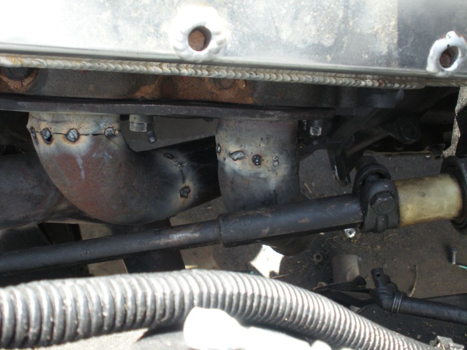 Exhaust pipes welded to manifold, steering shaft, and radiator