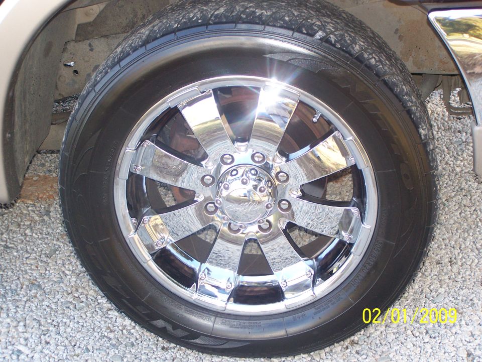 Chrome multi-spoke wheel with Nitto tire on gravel, dated 02/01/2009