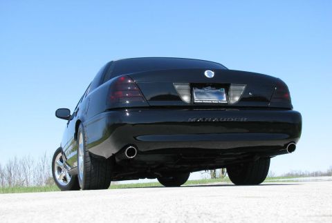 2003 Mercury Marauder - The rear of a black sedan with dual exhaust pipes is shown under a clear blue sky.