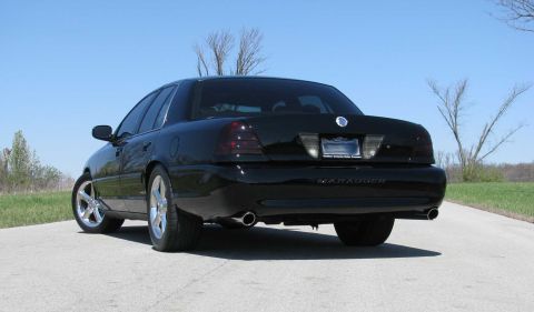 2003 Mercury Marauder - Rear view of a black 2003 Mercury Marauder parked on a paved surface under a clear blue sky.