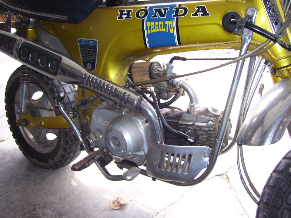 Gold Honda CT70 minibike left side close-up of engine, cone air filter and TRAIL70 decal