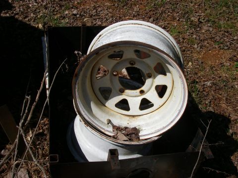1978 Ford Bronco - Two white steel wheels are shown, likely for a truck or SUV, resting outdoors.
