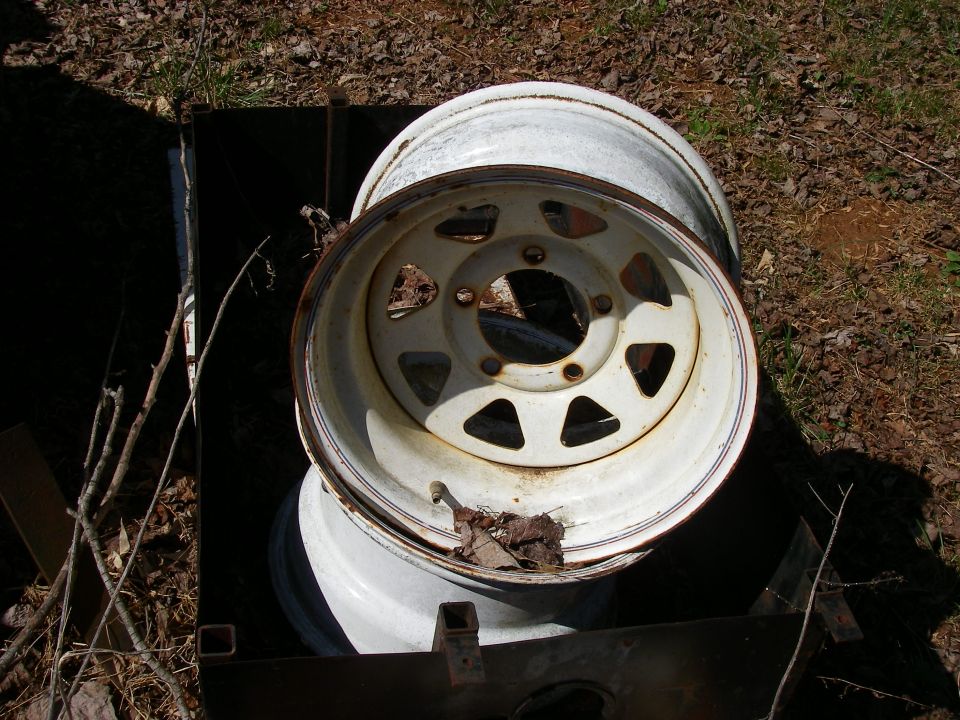 Two white steel wheels with five triangular cutouts