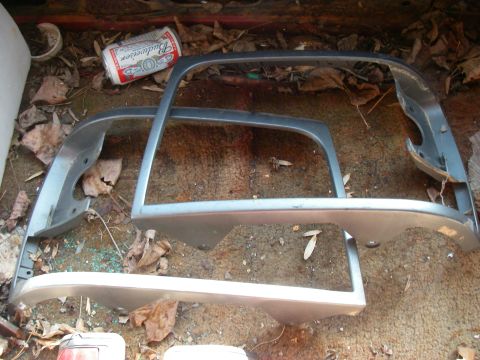 1978 Ford Bronco - Several chrome trim pieces and a discarded beer can are visible inside the trunk of a vehicle.
