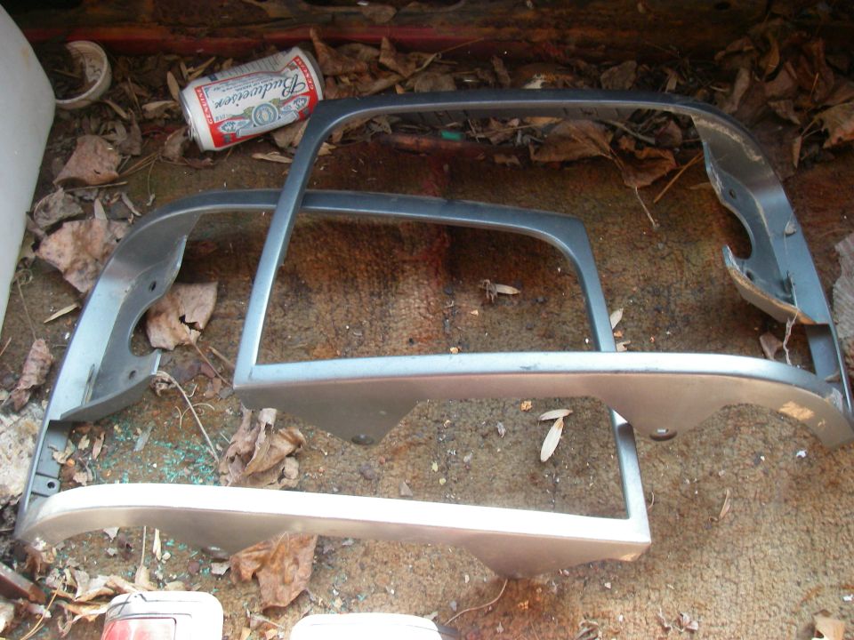 Car trim pieces and a Budweiser can in a vehicle's trunk