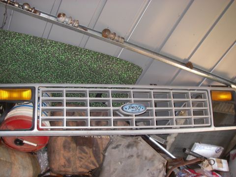 1978 Ford Bronco - Front grille assembly for a 1978 Ford Bronco, the iconic Ford oval emblem and amber turn signal lights.