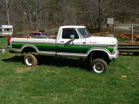 1978 Ford Bronco - This lifted Ford pickup truck features a two-tone paint scheme with green accents along the body.