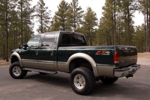2003 Ford F-350 - The 2003 Ford F-350 pickup truck is viewed from a three-quarter front angle, with a wooded area behind it.