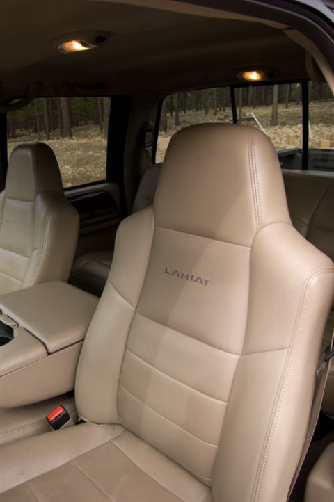 2003 Ford F-350 - The interior of a truck cab shows tan leather seats with 'Lariat' stitching.