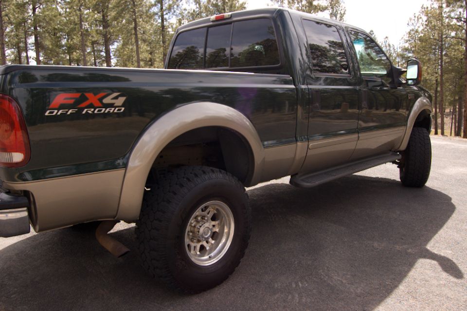 Dark green and tan Ford F-250/F-350 Super Duty pickup truck with FX4 Off Road decals on the bed