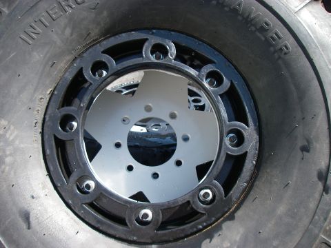 1978 Ford Bronco - A close-up view of a tire and wheel assembly, a custom star design on the wheel.