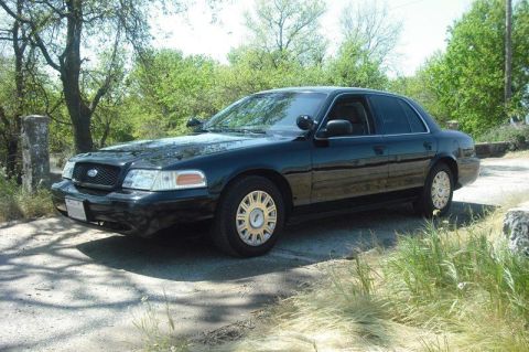 2003 Ford Crown Victoria - This black 2003 Ford Crown Victoria is seen from a 3q-front angle, parked outdoors.