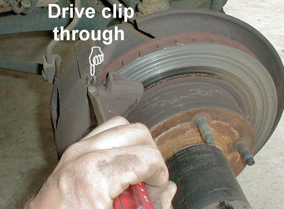 Punch and hammer driving a clip through a brake rotor and hub, 'Drive clip through' label