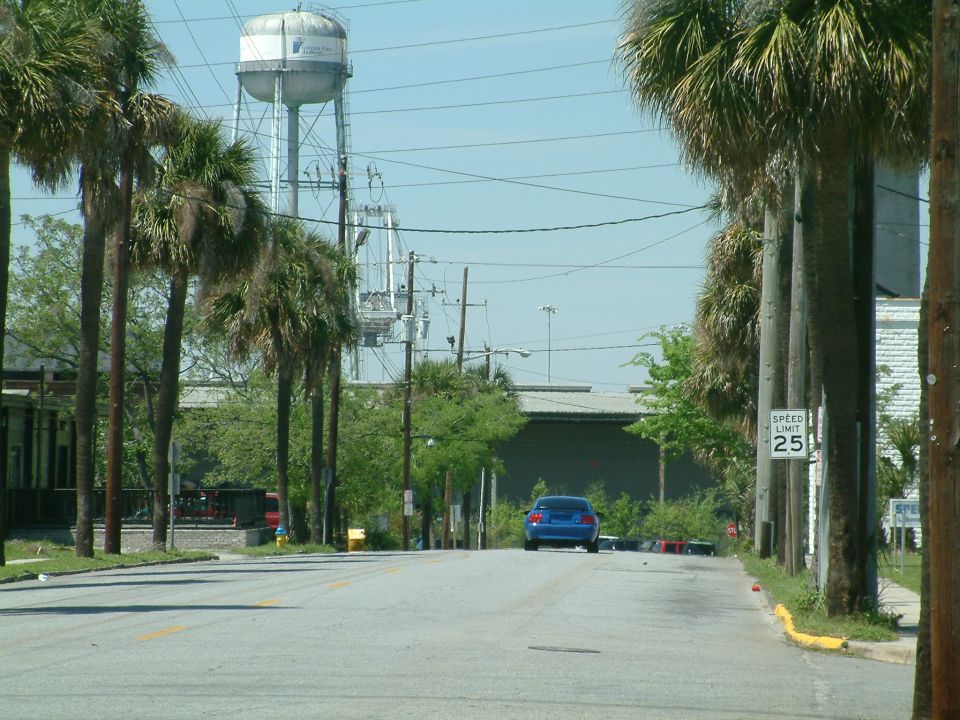 Blue 1992 Ford Bronco parked on a road with palm trees and a speed limit sign.