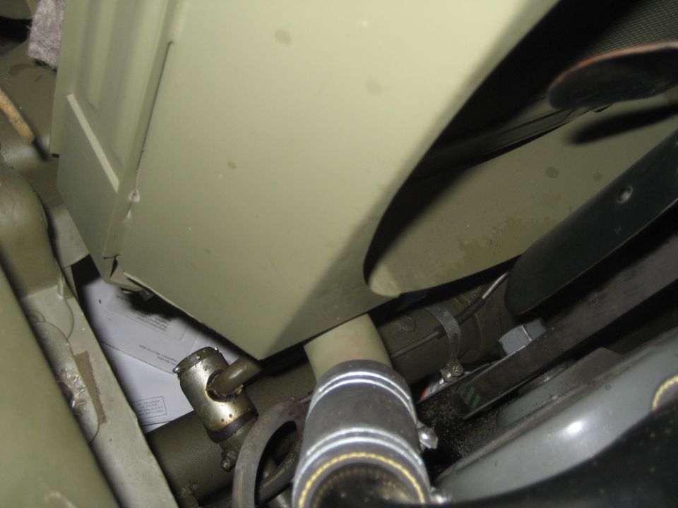 Close-up of olive green engine bay with hoses and clamps