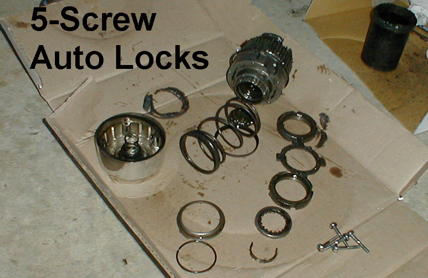 Disassembled 5-screw automatic locking hub parts laid out on cardboard with springs and rings