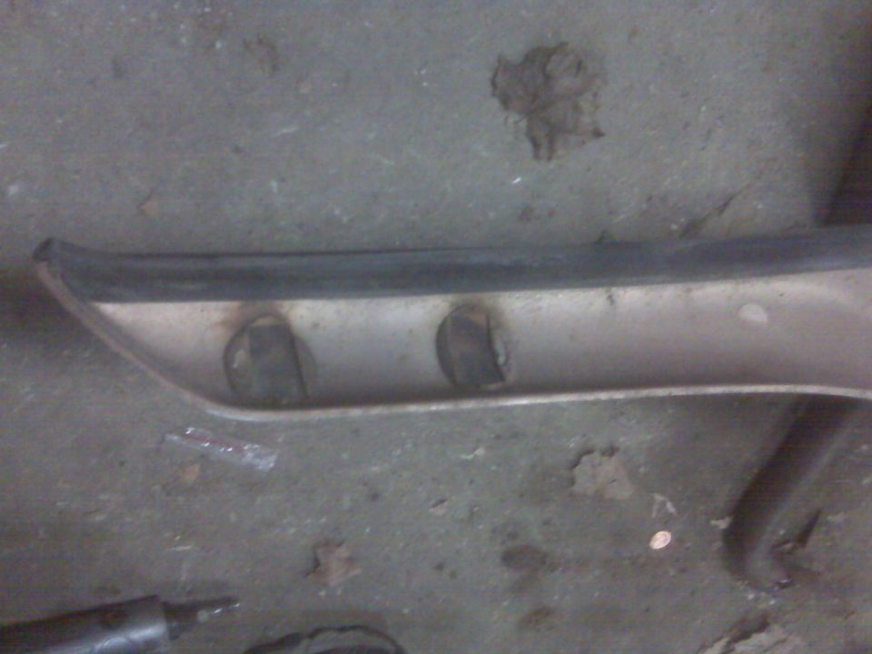 Beige car part with black trim and two circular openings.