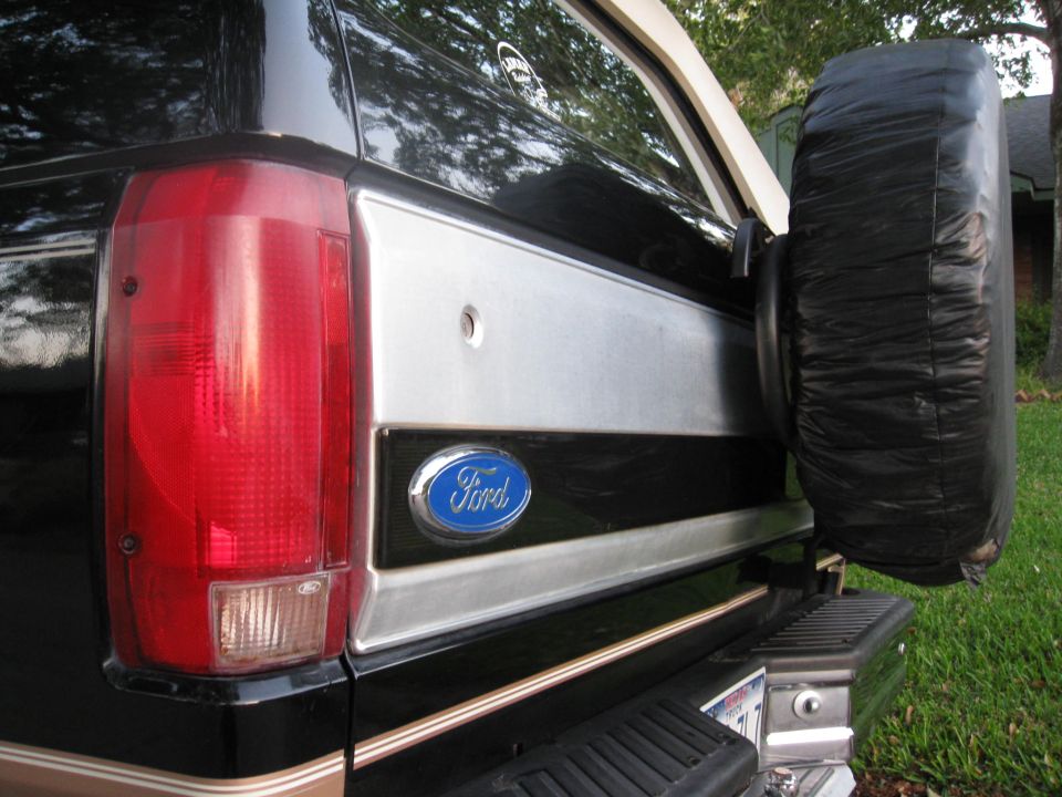 Rear driver's side of a black Ford Bronco with spare tire and Ford emblem.